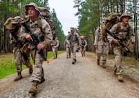 U.S. Marine Gunnery Sgt. Brent Downing (center), a company gunnery sergeant with Bravo Company, 1st Battalion, 23rd Marine Regiment, 4th Marine Division, motivates Marines during a ruck march at Barksdale Air Force Base, La., March 18, 2016. Downing provided Marines with feedback while looking for injuries and signs of exhaustion. (U.S. Air Force photo/Senior Airman Mozer O. Da Cunha)