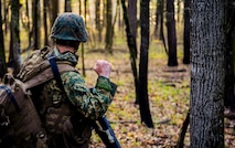 U.S. Marine with Bravo Company, 1st Battalion, 23rd Marine Regiment, 4th Marine Division, gives a non-verbal halt signal during a patrol exercise at Barksdale Air Force Base, La., March 18, 2016. Non-verbal communication was used to move within the training area without alerting simulated enemies. (U.S. Air Force photo/Senior Airman Mozer O. Da Cunha)