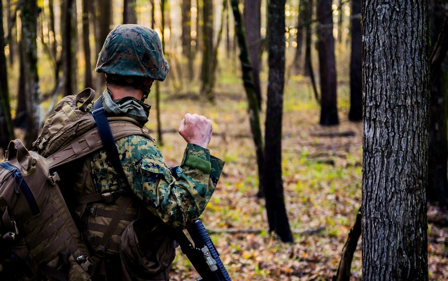 U.S. Marine with Bravo Company, 1st Battalion, 23rd Marine Regiment, 4th Marine Division, gives a non-verbal halt signal during a patrol exercise at Barksdale Air Force Base, La., March 18, 2016. Non-verbal communication was used to move within the training area without alerting simulated enemies. (U.S. Air Force photo/Senior Airman Mozer O. Da Cunha)