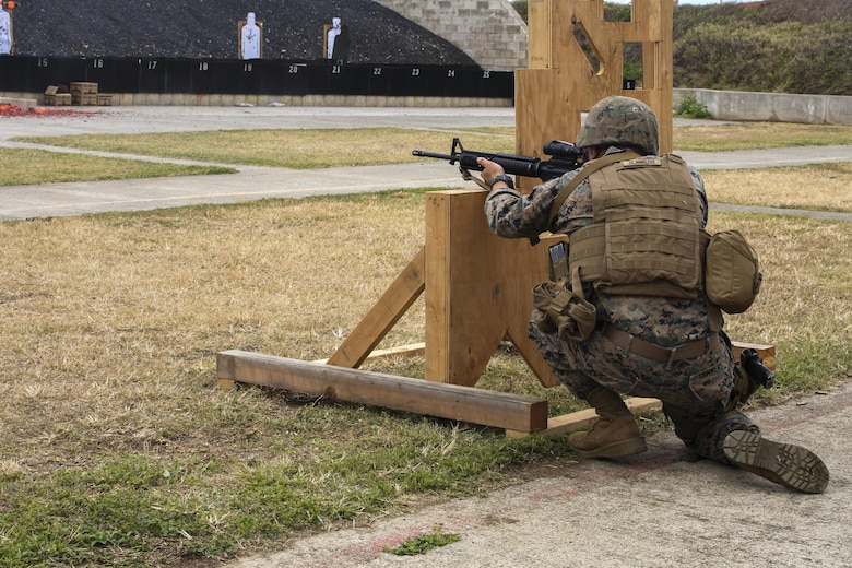 MARINE CORPS BASE HAWAII — Cpl. Zachary Summers, a radio operator with 3rd Radio Battalion, kneels behind a barrier during a Pacific Combat Shooting Match at the Kaneohe Bay Range Training Facility aboard Marine Corps Base Hawaii, March 16, 2016. Teams from different units used various weapons and tactics to achieve the fastest time possible on different courses of fire, while earning points for awards during the competition. Marines from the Marine Corps Combat Shooting Team instructed and gave advice to the Marines participating in the event. (U.S. Marine Corps Photo by Lance Cpl. Jesus Sepulveda Torres)