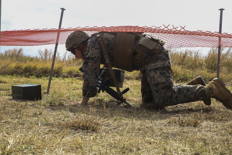 MARINE CORPS BASE HAWAII —  Cpl. Bradley Saunders, an infantry assaultman with Fox Company, 2nd Battalion, 3rd Marine Regiment, and a Platteville, Wis., native, low crawls under netting while carrying ammo cans during the Pacific Combat Shooting Match at the Kaneohe Bay Range Training Facility aboard Marine Corps Base Hawaii, March 16, 2016 Teams from different units used various weapons and tactics to achieve the fastest time possible on different courses of fire, while earning points for awards during the competition. Marines from the Marine Corps Combat Shooting Team instructed and gave advice to the Marines participating in the event. (U.S. Marine Corps Photo by Lance Cpl. Jesus Sepulveda Torres)