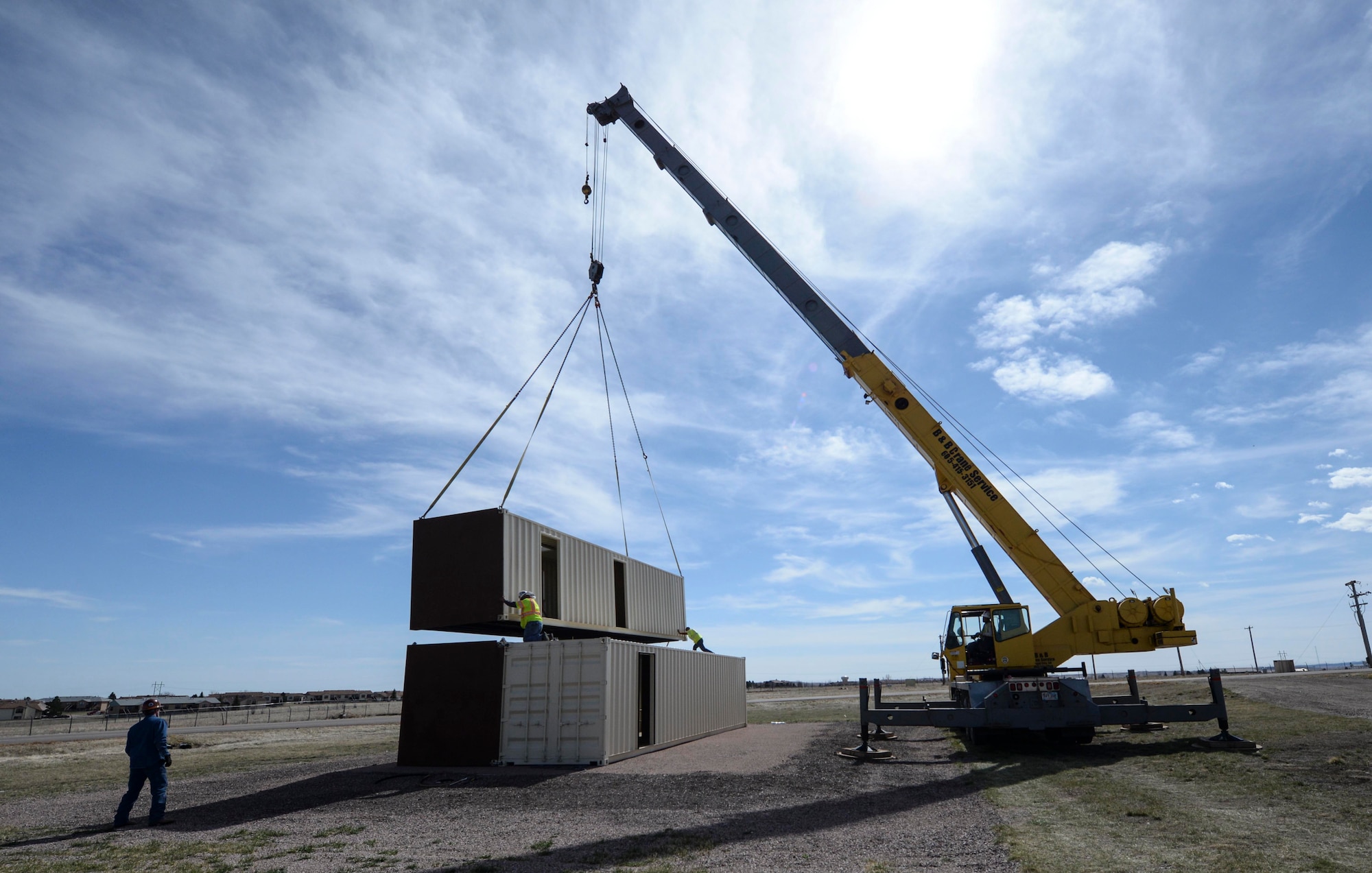 Independent contractors use a crane to place a conex building during the construction of the Military Operations Urban Terrain training area at Ellsworth Air Force Base, S.D., March 21, 2016. The facility will be used bi-weekly by the 28th Security Forces Squadron to cover scenarios such as active shooters, work place violence, combat readiness tasks and shoot-move-communicate exercises. (U.S. Air Force photo by Airman 1st Class Sadie Colbert/Released)
