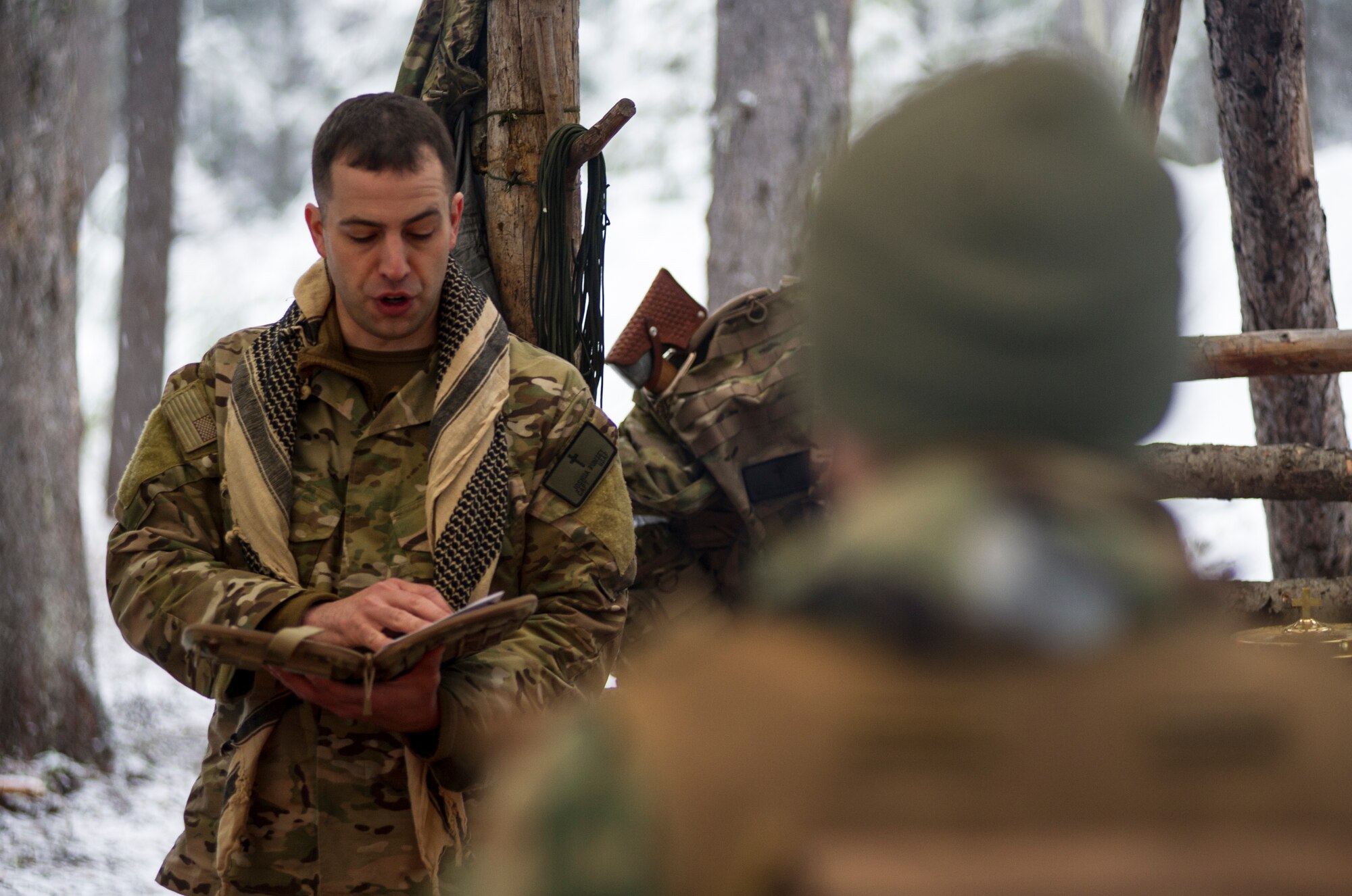 Chaplain(Capt.)  Joshua Rumsey, 336th Training Group chaplain , reads the Easter story from scripture to Airmen in the field as part of an Easter service March 27, 2016, at Fairchild Air Force Base, Wash. Rumsey  and Major Jonathan Harmon, 336th Training Support Squadron  combat rescue officer , coordinated with leadership on base and the churches to be able to provide the services correctly. (U.S. Air Force photo/Airman 1st Class Sean Campbell)