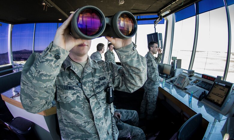 Senior Airman John Lewis, 92nd Operation Support Squadron air traffic control journeyman, uses binoculars to look down the flight line while completing his daily duties March 18, 2016, at Fairchild Air Force Base, Wash. A big part of air traffic control is managing time. Real-time coordination of airspace happens every day Between the Fairchild ATC tower and Spokane International Airport’s tower. (U.S. Air Force photo/Airman 1st Class Sean Campbell)