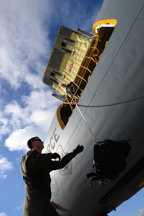 U.S. Air Force Senior Airman Christopher Kelley, 100th Aircraft Maintenance Squadron flying crew chief, lowers a bag down from a KC-135 Stratotanker to U.S. Air Force Staff Sgt. Austin Brookshire, 100th AMXS flying crew chief, March 29, 2016, on RAF Mildenhall, England. This aircraft is the primary KC-135 flown by the wing commander and the top choice for static displays at special events. (U.S. Air Force photo by Staff Sgt. Micaiah Anthony/Released)