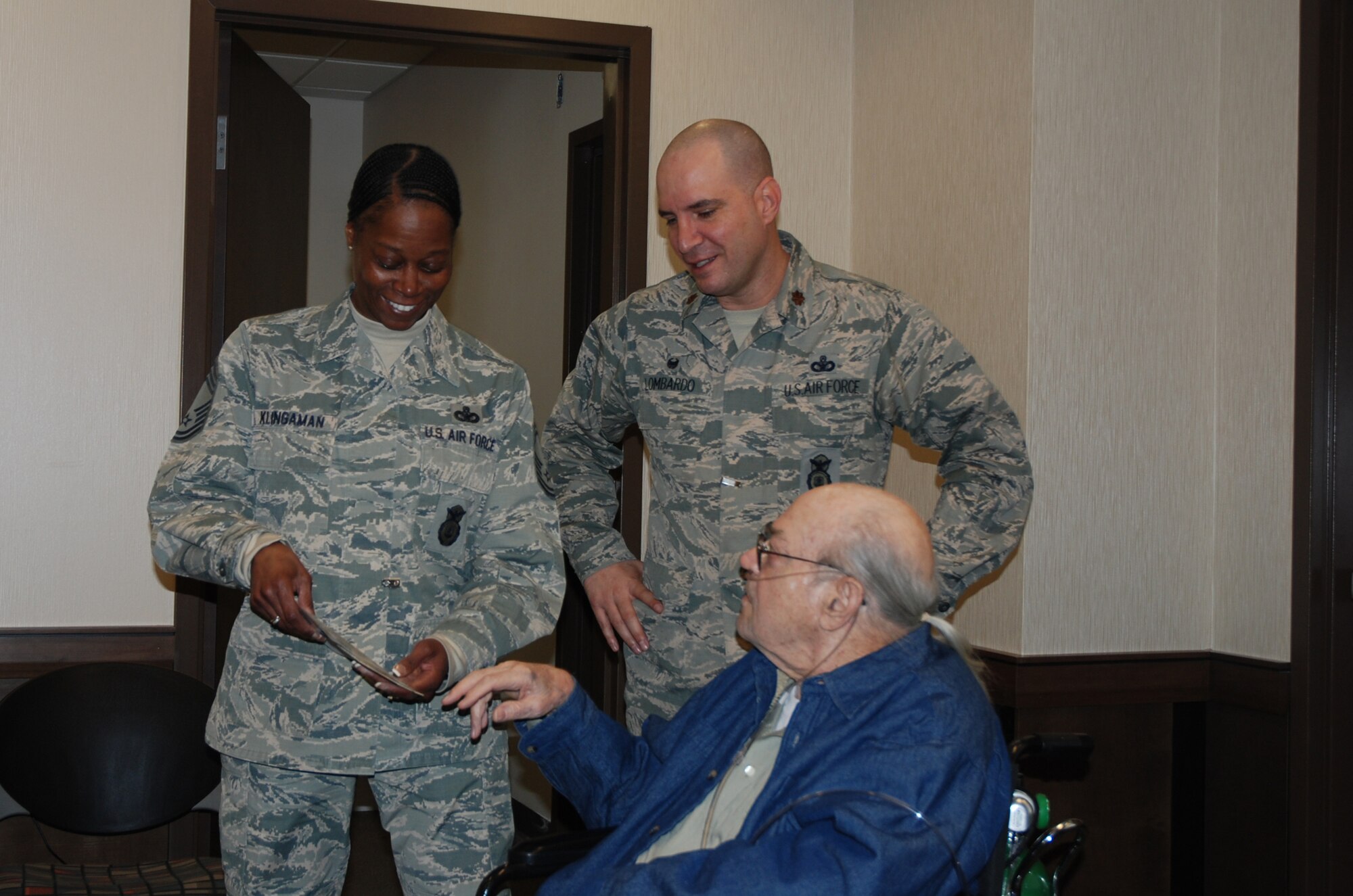 CHEYENNE MOUNTAIN AIR FORCE STATION, Colo. – Bill Bunker shows part of his Cheyenne Mountain Air Force Station memorabilia collection to Chief Master Sgt. Nanette Klingaman, 721st Mission Support Group superintendent and Maj. Kevin B. Lombardo, 721st Security Forces Squadron commander during a recent visit to the facility. Bunker served as an Air Force Policeman when CMAFS went operational and has not been back since his retirement nearly 40 years ago. (U.S. Air Force photo by Dave Smith)