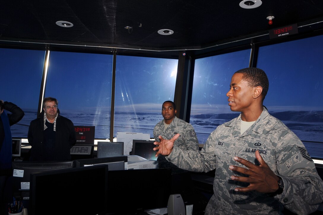 THULE AIR BASE, Greenland - Tech. Sgt. Jerome Cole (right) and Tech. Sgt. Andre Heags, 821st Support Squadron, brief members of the Danish Parliament and U.S. Embassy about tower procedures during a visit to Thule Air Base, Greenland on March 23, 2016. After visiting the air traffic control tower, the team received a mission brief. (courtesy photo)