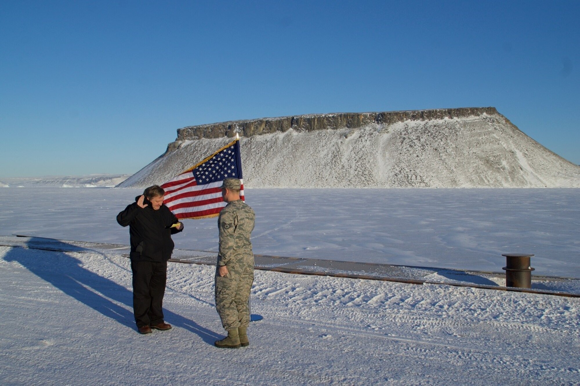 THULE AIR BASE, Greenland - Retired Col. Ralph O. Stoffler, Headquarters Air Force’s director of weather, administers the Oath of Enlistment to Staff Sgt. Miles Sumner, 821st Support Squadron, on Delong Pier at Thule Air Base, Greenland. Stoffler visited Thule to first-hand the transition of weather support from contractors to Airmen. (U.S. Air Force photo by Master Sgt. Stoney M. Bair)
