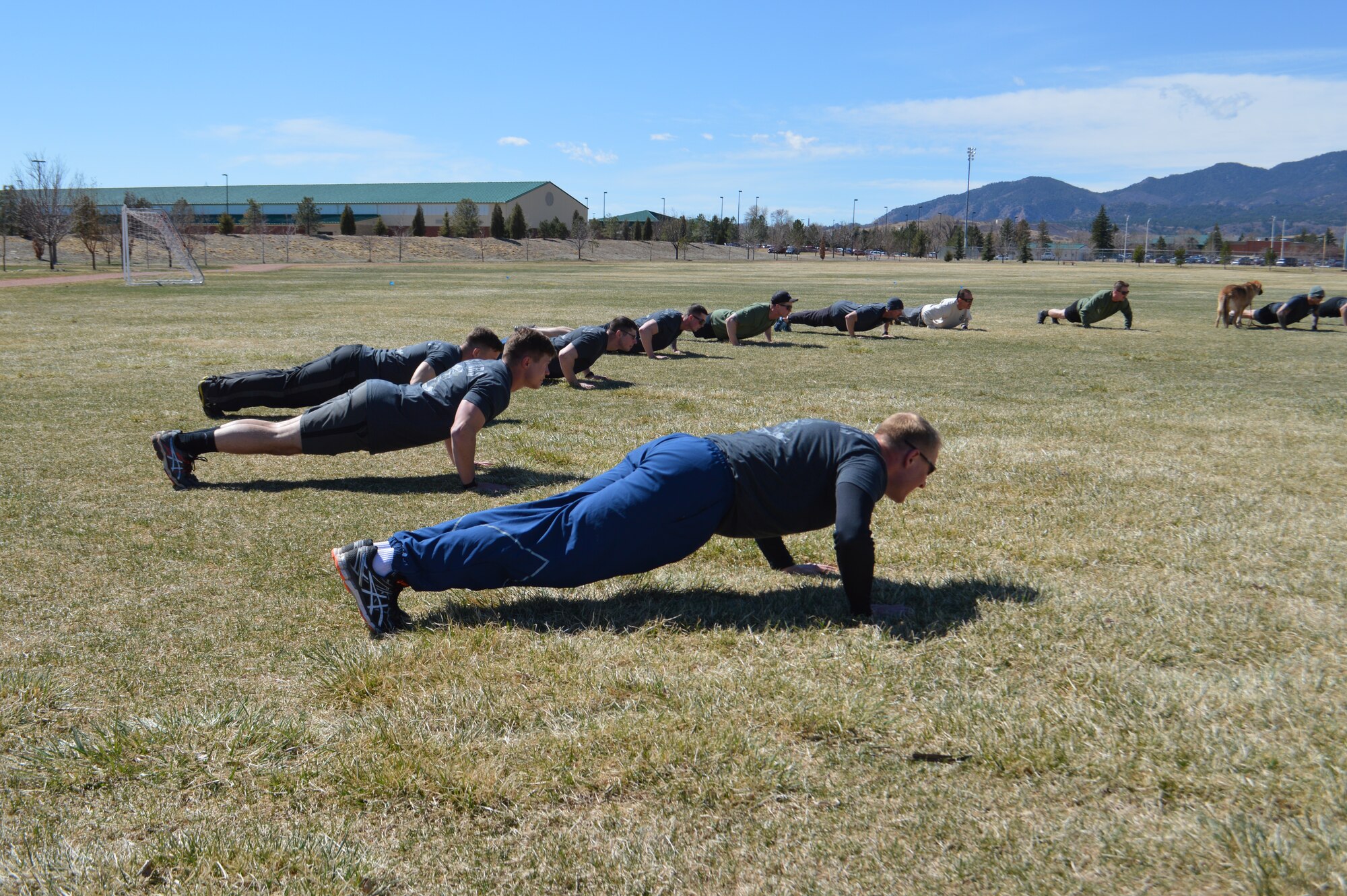 FORT CARSON, Colo. - Lt. Col. John Blocher (front), 13th Air Support Operations Squadron commander, and squadron Airmen perform pushups in honor of fallen Tactical Air Control Party Airmen at the conclusion of the Fifth Annual 24-hour Challenge Run at Fort Carson’s Pershing Field March 24. (Photo by Dani Johnson)