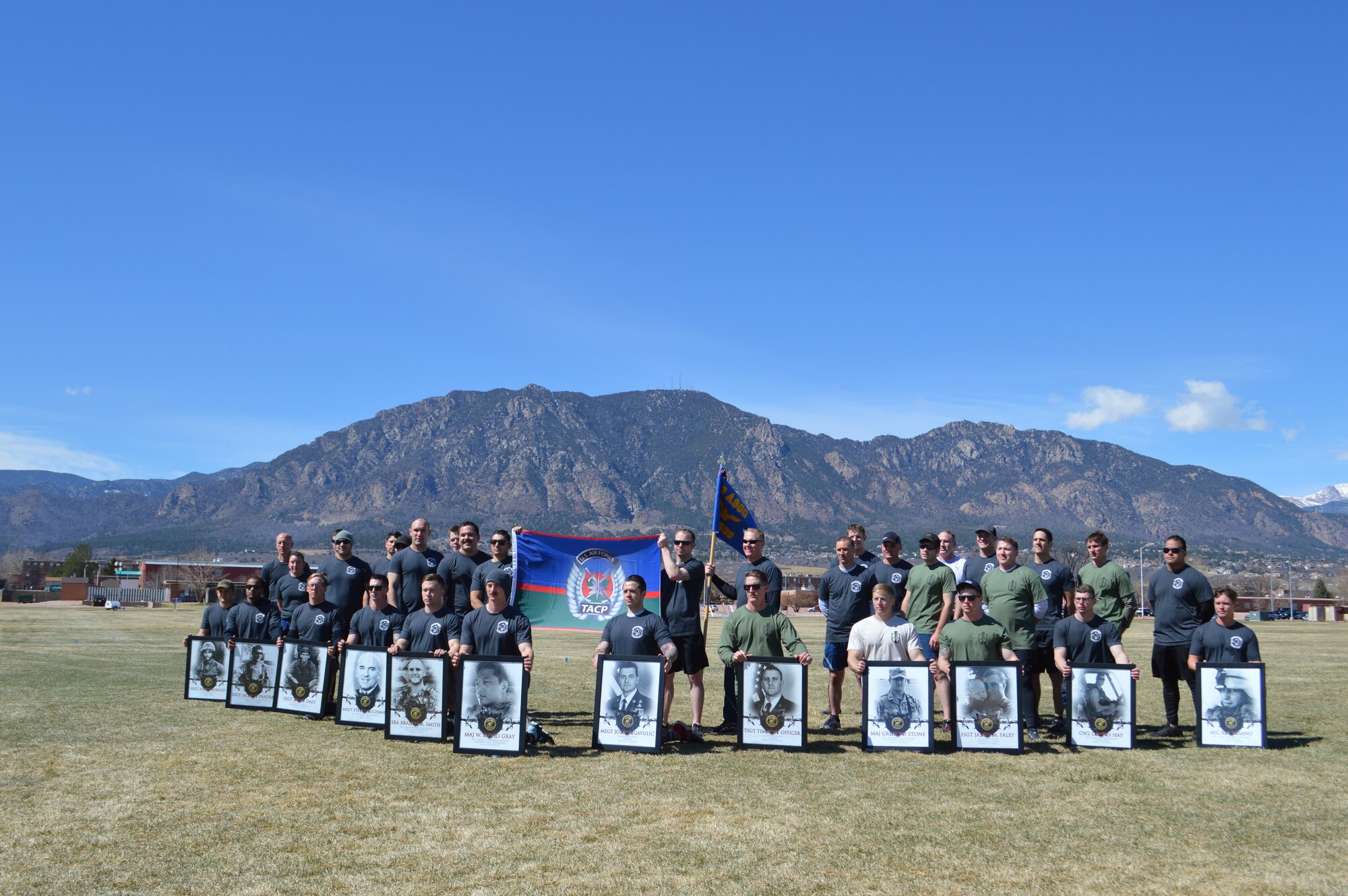 FORT CARSON, Colo. - Airman with the 13th Air Support Operations Squadron hold the images of Tactical Air Control Party Airmen who have lost their lives either deployed or in training at the conclusion of the Fifth Annual 24-hour Challenge Run at Fort Carson’s Pershing Field March 24. (Photo by Dani Johnson)