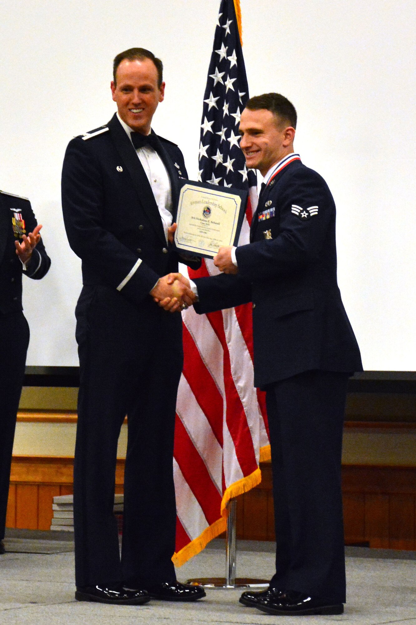 120th Airlift Wing Commander Col. Lee Smith presents an Airman Leadership School diploma to Senior Airman Nicholaus Schwall, March 22, 2016. Schwall was one of 32 students who graduated from ALS Class 16-D at Malmstrom Air Force Base, Mont. (U.S. Air National Guard photo by Senior Master Sgt. Eric Peterson)