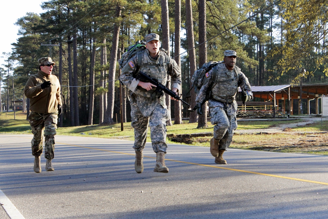 Army Sgt. Sydnee Coffman, left, cheers on Army Staff Sgt. Robert Miller, center, and Army Spc. Phillip Small during a 12-mile ruck march which was part of the 2016 Best Warrior and Drill Sergeant of the Year competition at Fort Jackson, S.C., March 22, 2016. Coffman and Small are assigned to the 104th Training Division and Miller is assigned to the 98th Training Division. The competition  determines the top noncommissioned officer and junior enlisted soldier who will represent the 108th Training Command at the Army Reserve Best Warrior competition later this year at Fort Bragg, N.C. Army photo by Maj. Michelle Lunato