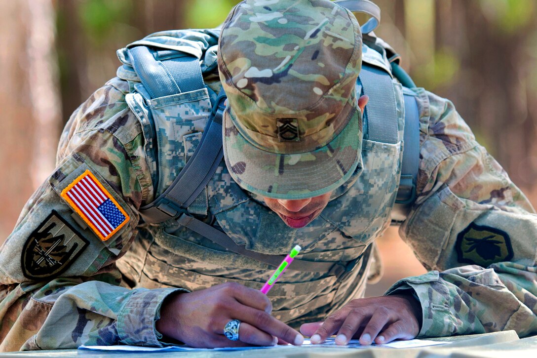 Army Staff Sgt. Kenneth Watson plots points on a map before participating in the night land navigation course part of the 2016 Best Warrior and Drill Sergeant of the Year competition at Fort Jackson, S.C., March 22, 2016. Watson is assigned to the 98th Training Division. Army photo by Maj. Michelle Lunato 