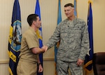 Busch presents a ceremonial coin to Navy Lt. Joseph Thomas for his work supporting expeditionary operations for DLA Disposition Services