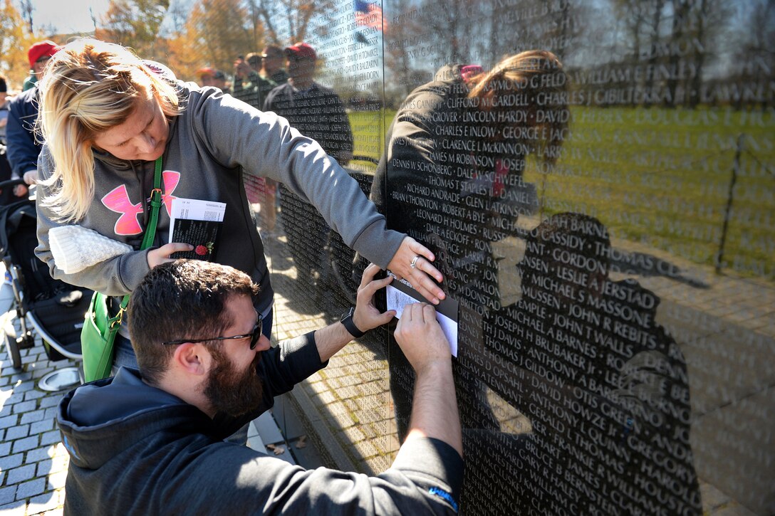 Michael Stinson and his wife, Monica, from Arizona, pay tribute to Monica’s father by making a rubbing of his name at the Vietnam Veterans Memorial in Washington, D.C., March 29, 2016. DoD photo by Marvin Lynchard