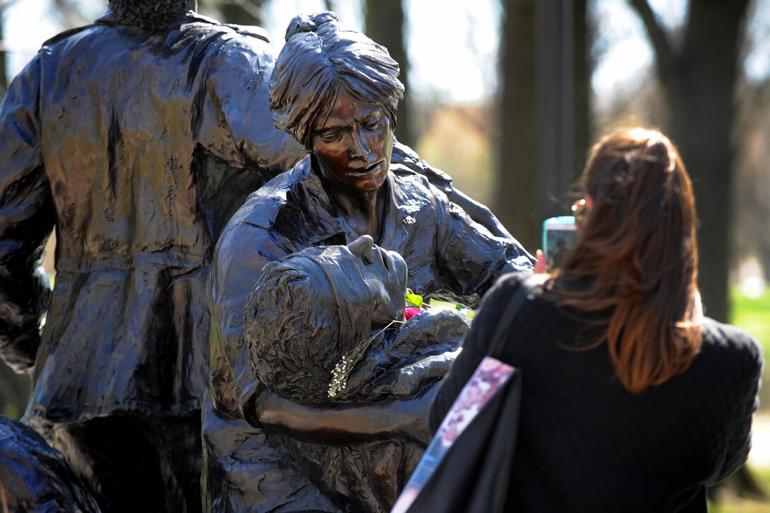 A visitor takes a photo of the Vietnam Women’s Memorial at the Vietnam Veterans Memorial in Washington, D.C., March 29, 2016. DoD photo by Marvin Lynchard