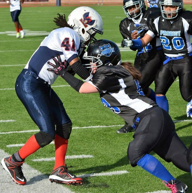 Navy Petty Officer 1st Class Colleen Dibble, right, a master-at-arms assigned to Naval Support Activity Bethesda, Md., makes a tackle during a Washington Prodigy game against the Philadelphia Firebirds in Washington, May 9, 2015. Courtesy photo