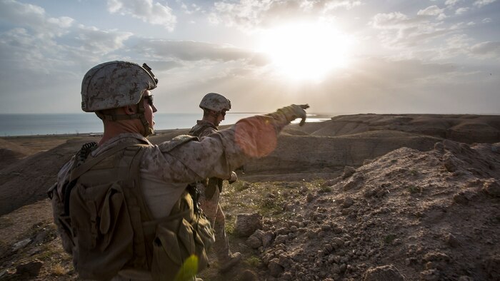 U.S. Marine Sgt. Robert McCabe, a section leader with Company B, 1st Battalion, 7th Marine Regiment, Special Purpose Marine Air Ground Task Force - Crisis Response - Central Command, points out areas of interest to members of his team during a perimeter patrol in Al Taqaddum, Iraq, March 21, 2016. SPMAGTF-CR-CC Marines are responsible for the force protection of coalition assets at some Combined Joint Task Force – Operation Inherent Resolve bases within the U.S. Central Command area of responsibility as part of the effort to defeat the Islamic State of Iraq and Levant.