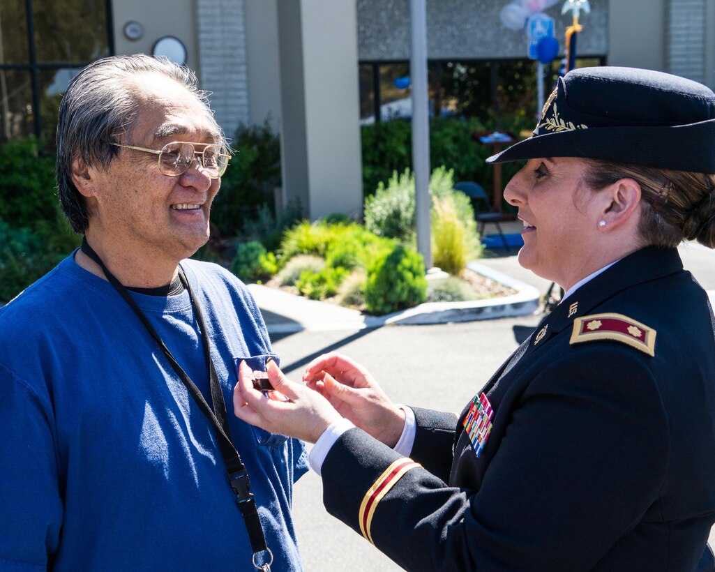 Maj. (Retired) Andrea Singer, the 311th Sustainment Command (Expeditionary) Resource Management Officer, presents Vietnam Veteran Lapel Pins to vets at the West Los Angeles Vet Center, Culver City, Calif., March 29, 2016. Engraved on the pins is "A Grateful Nation Thanks and Honors You."