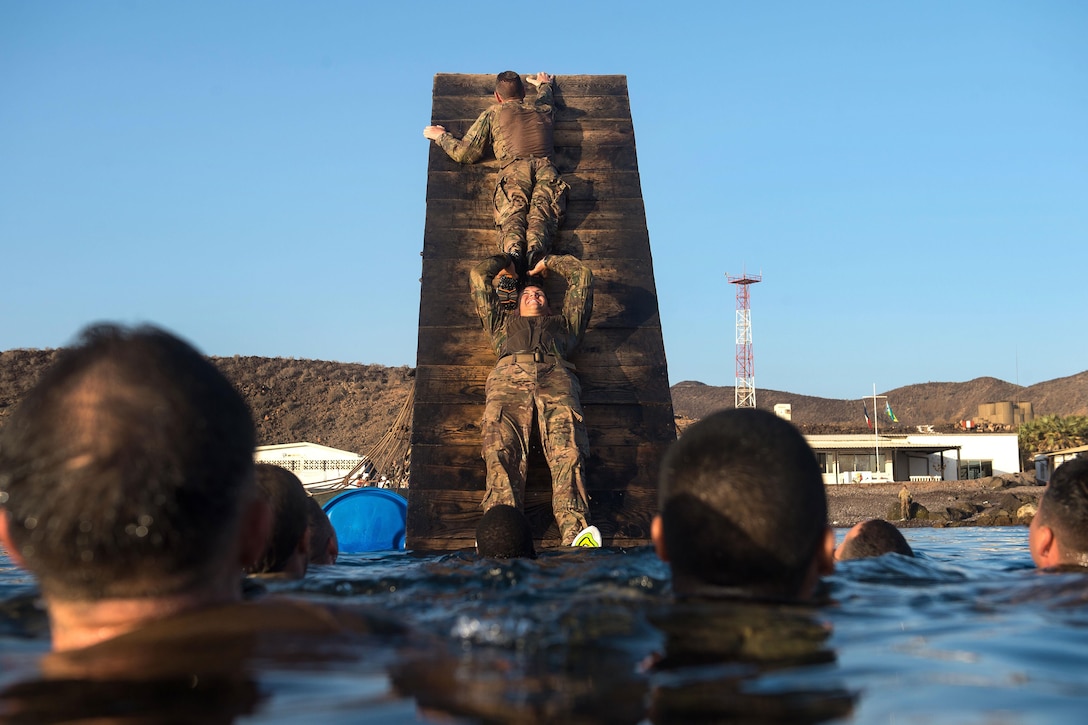 U.S. soldiers negotiate a water obstacle during a desert commando course in Arta, Djibouti, March 15, 2016. Air Force photo by Tech. Sgt. Barry Loo