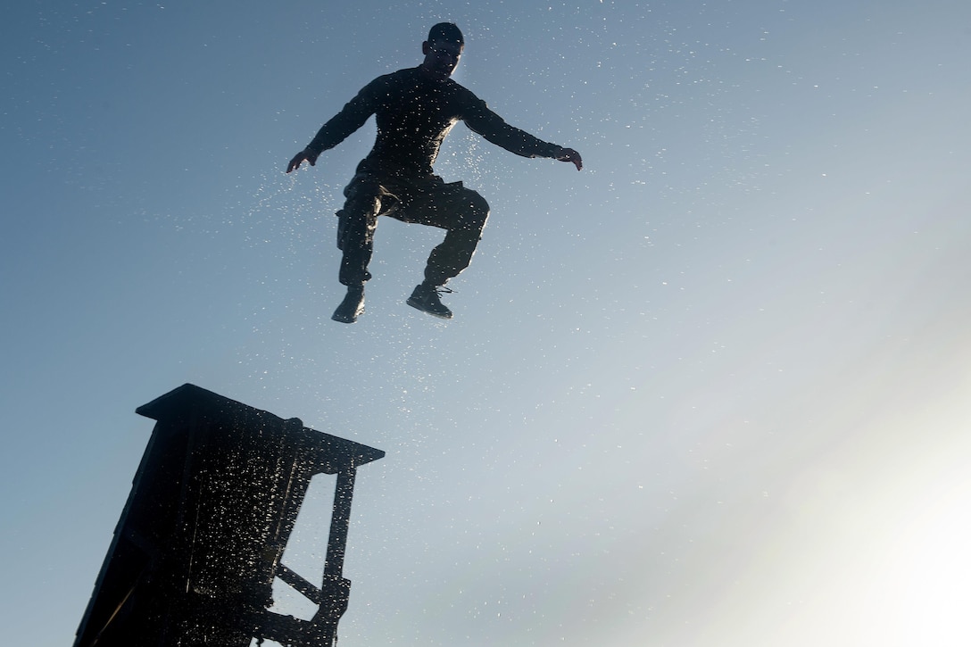 A U.S. soldier jumps off a water obstacle during a desert commando course in Arta, Djibouti, March 15, 2016. Air Force photo by Tech. Sgt. Barry Loo