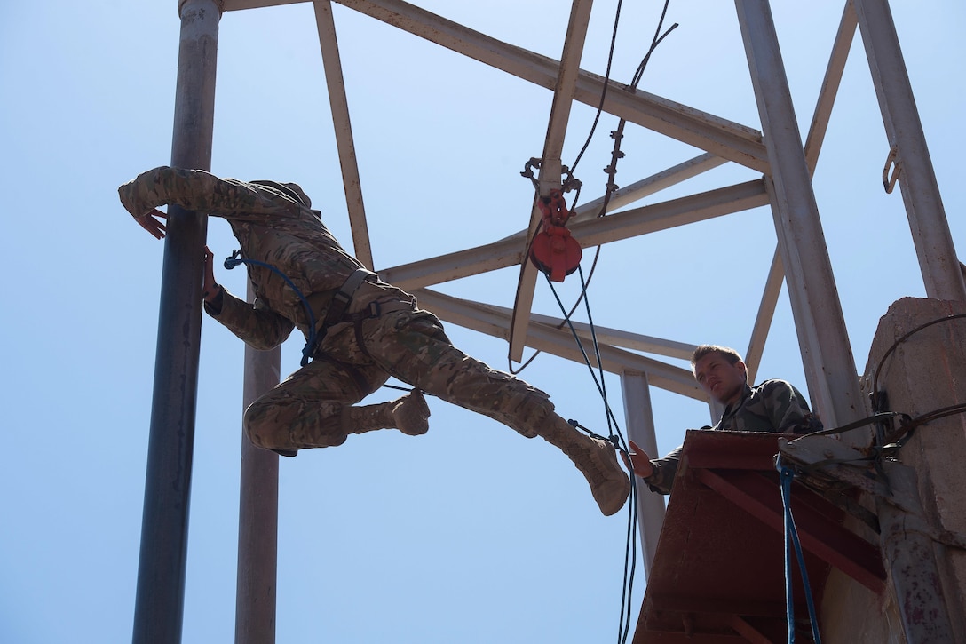 A U.S. soldier slides down a pipe as a French Foreign Legion soldier observes during a desert commando course in Arta, Djibouti, March 15, 2016. Air Force photo by Tech. Sgt. Barry Loo