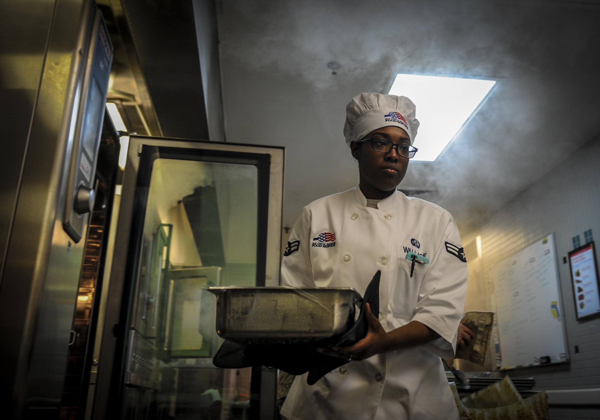 Airman 1st Class Eboni Wallace, a food service journeyman with the 1st Special Operations Force Support Squadron, removes food from an oven at The Reef, Hurlburt Field, Fla., March 28, 2016. The Reef dining facility prepares food for 400-500 Air Commandos every day. (U.S. Air Force photo by Senior Airman Meagan Schutter)