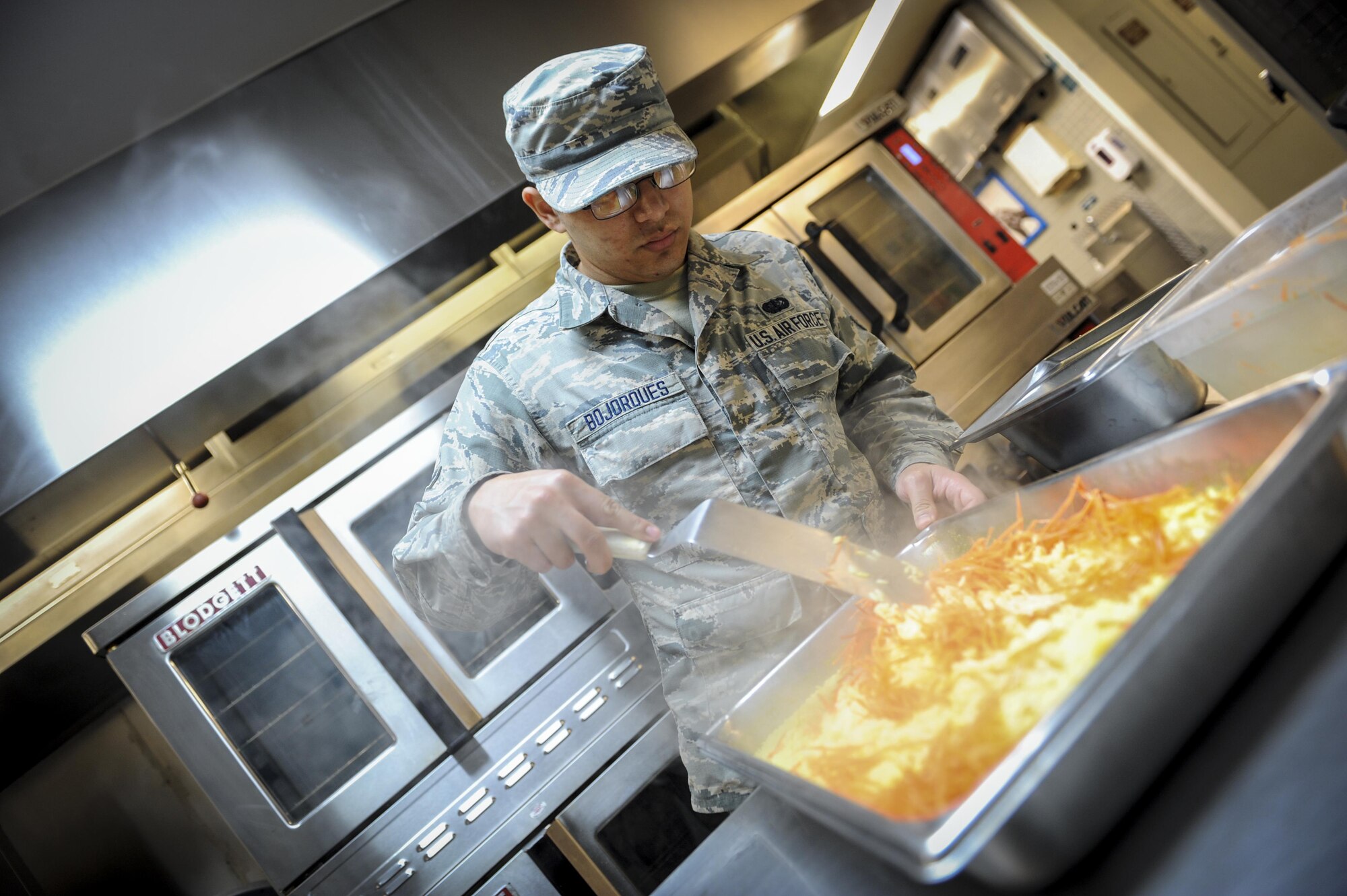 Airman 1st Class Richard Bojoroues, a food service journeyman with the 1st Special Operations Force Support Squadron, stirs carrots into rice at The Reef, Hurlburt Field, Fla., March 28, 2016. The Reef dining facility prepares food for 400-500 Air Commandos every day. (U.S. Air Force photo by Senior Airman Meagan Schutter)