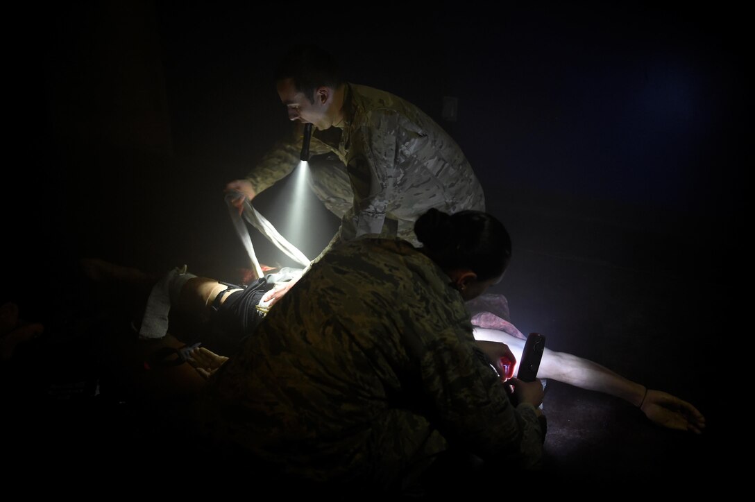 Air Force Staff Sgt. Alicia Rivera, foreground, and Army Spc. Garrett Small apply bandages to the wounds on a training mannequin during the hands-on portion of tactical combat casualty care training at Fort Bliss, Texas, March 24, 2016. Air Force photo by Staff Sgt. Jonathan Snyder
