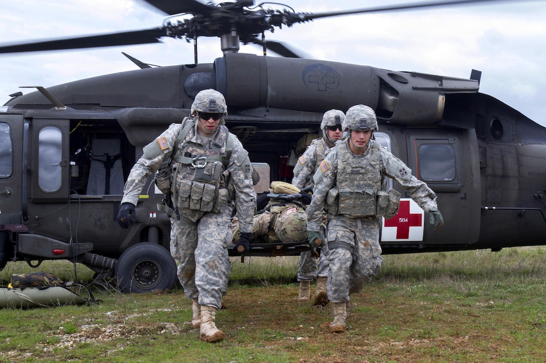 Soldiers unload a simulated casualty from a UH-60 Black Hawk helicopter during medevac training at Camp Bondsteel, Kosovo, March 15, 2016. Army photo by Staff Sgt. Thomas Duval