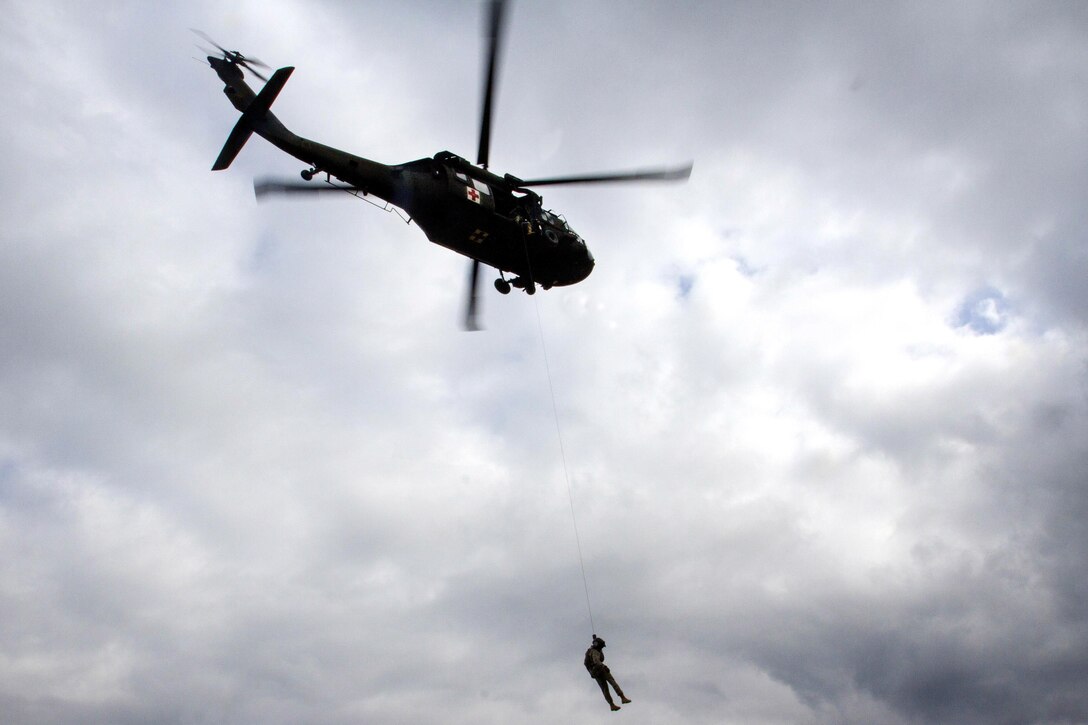 A soldier is lowered from a UH-60 Black Hawk helicopter during medevac training at Camp Bondsteel, Kosovo, March 15, 2016. The soldier is a crew chief, and the pilots are assigned to the Arizona National Guard’s 5th Battalion, 159th Air Ambulance, Detachment D. Army photo by Staff Sgt. Thomas Duval