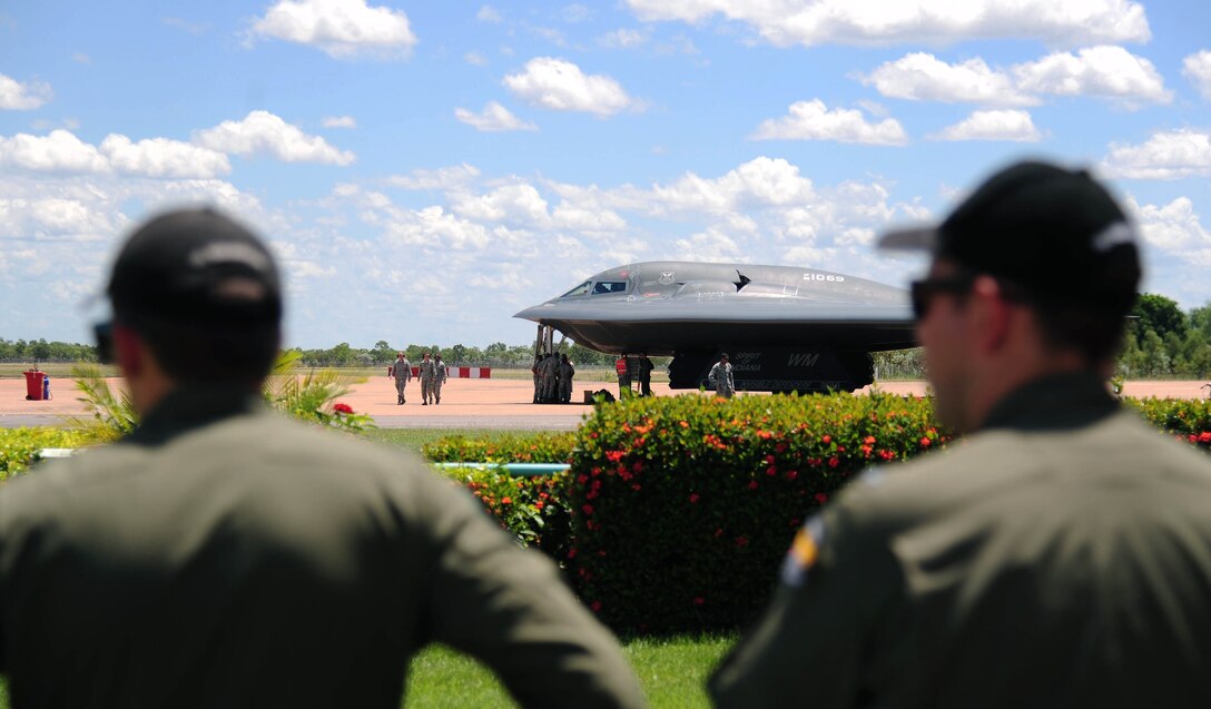 Royal Australian Air Force pilots watch as U.S. Air Force B-2 Spirit bomber crews, deployed from Whiteman Air Force Base, Mo., perform an engine running crew change at RAAF Base Tindal, Australia, March 22, 2016.  The B-2 was one of three that were deployed to the Indo-Asia-Pacific region from March 8 through 29 to enhance bomber crew readiness and proficiency and to integrate capabilities with key regional partners. U.S. Strategic Command bombers regularly rotate through the Indo-Asia-Pacific region to conduct theater security cooperation engagements with U.S. allies and partners and demonstrate a shared commitment to promoting security and stability in the region. (U.S. Air Force photo by Senior Airman Joel Pfiester/Released)