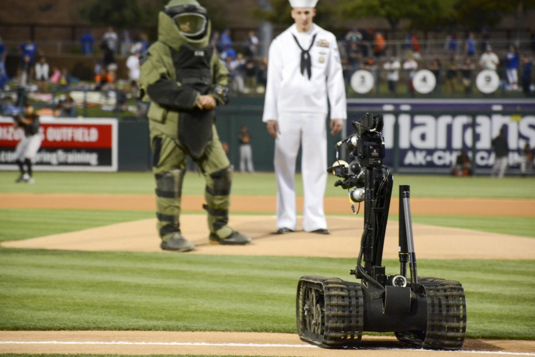 A Talon bomb disposal robot brings out the ball for the first pitch at a spring training baseball game between the Los Angeles Dodgers and San Francisco Giants as part of Navy Week in Phoenix, March 25, 2016. Navy photo by Seaman Mickey Treigle
