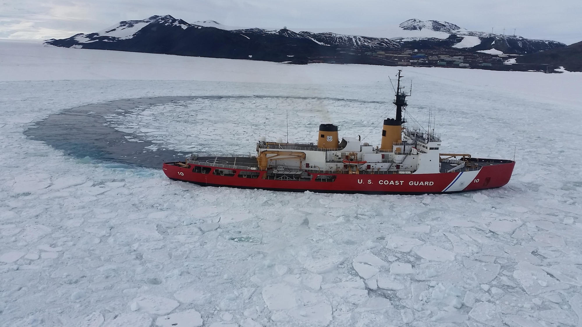 The U.S. Coast Guard's Icebreaker POLAR STAR clears ice from Waterquarters Bay at McMurdo Station, Antarctica, Jan. 20, 2016, during Operation DEEP FREEZE, the Department of Defense's support of the U.S. Antarctic Program and the National Science Foundation. This year marked the 60th Anniversary of the operation. (Courtesy photo)