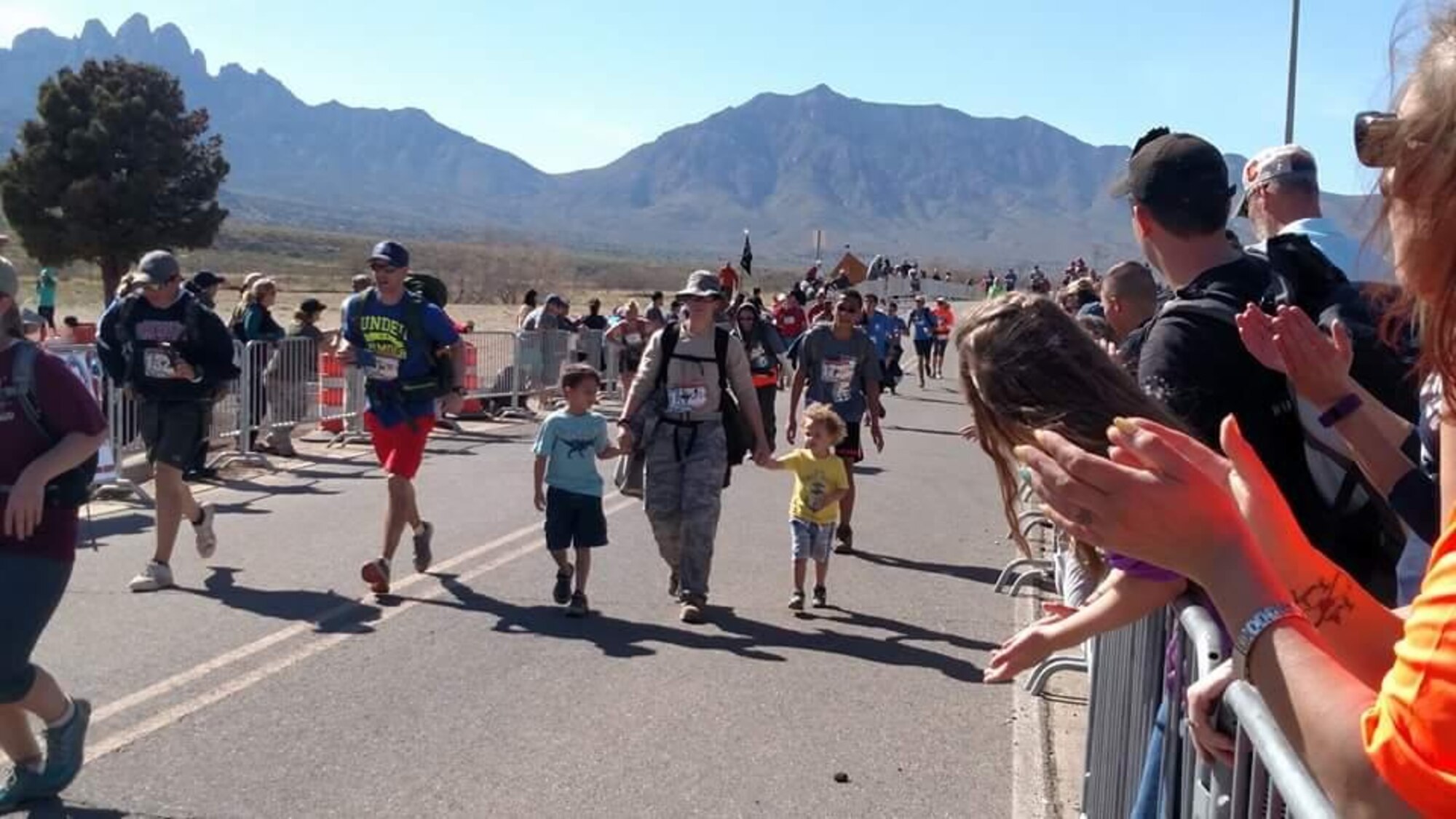 U.S. Air Force Tech. Sgt. Julia Getter, 53rd Test Support Squadron, crosses the finish line with her sons, 7-year-old Zackary and 2-year-old Zander, at the Bataan Memorial Death March, White Sands Missile Range, New Mexico, March 20, 2016. This was Getter’s fifth time participating in the Bataan Memorial Death March, which is held in honor of the service members who defended the Philippine Islands during World War II and were captured by the Japanese in 1942. (Courtesy photo/Released)