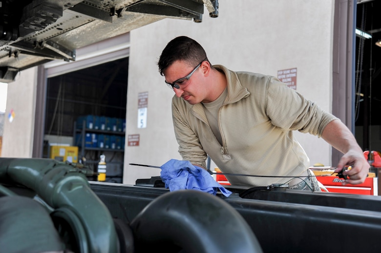Senior Airman Jonathan Rowley, 51st Logistics Readiness Squadron sorting generating and aircraft sustaining vehicle maintainer, checks oil on a Tunner 60K loader at Osan Air Base, Republic of Korea, March 30, 2016. The loader can transport six pallets of cargo for loading on commercial and military cargo aircraft. (U.S. Air Force photo by Staff Sgt. Jonathan Steffen/Released)