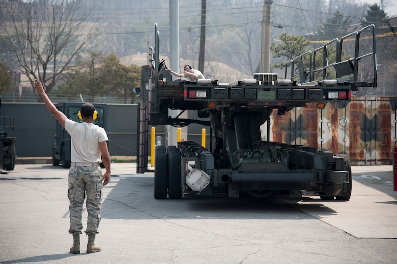 Staff Sgt. Sergio McLaughlin, 51st Logistics Readiness Squadron sorting generating and aircraft sustaining vehicle maintainer, checks turn signals for serviceability on a Tunner 60K loader at Osan Air Base, Republic of Korea, March 30, 2016. The loader can transport six pallets of cargo for loading on commercial and military cargo aircraft. (U.S. Air Force photo by Staff Sgt. Jonathan Steffen/Released)