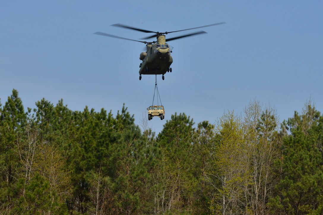 A CH-47 Chinook carries a high-mobility multipurpose wheeled vehicle during sling-load training at Fort Eustis, Va., March 24, 2016. The Chinook is a multirole aircraft used in contingency, humanitarian and disaster relief operations to transport troops, aid supplies, artillery, equipment and fuel. (U.S. Air Force photo by Staff Sgt. Natasha Stannard)