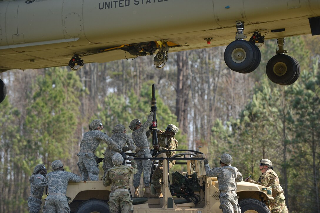 U.S. Soldiers assigned to the 689th Rapid Port Opening Element rig a high-mobility multipurpose wheeled vehicle to a CH-47 Chinook during sling-load training at Fort Eustis, Va., March 24, 2016. Sling-loading allows Soldiers to move equipment and cargo in harsh locations where roadways are unusable to transport vital materials. (U.S. Air Force photo by Staff Sgt. Natasha Stannard)