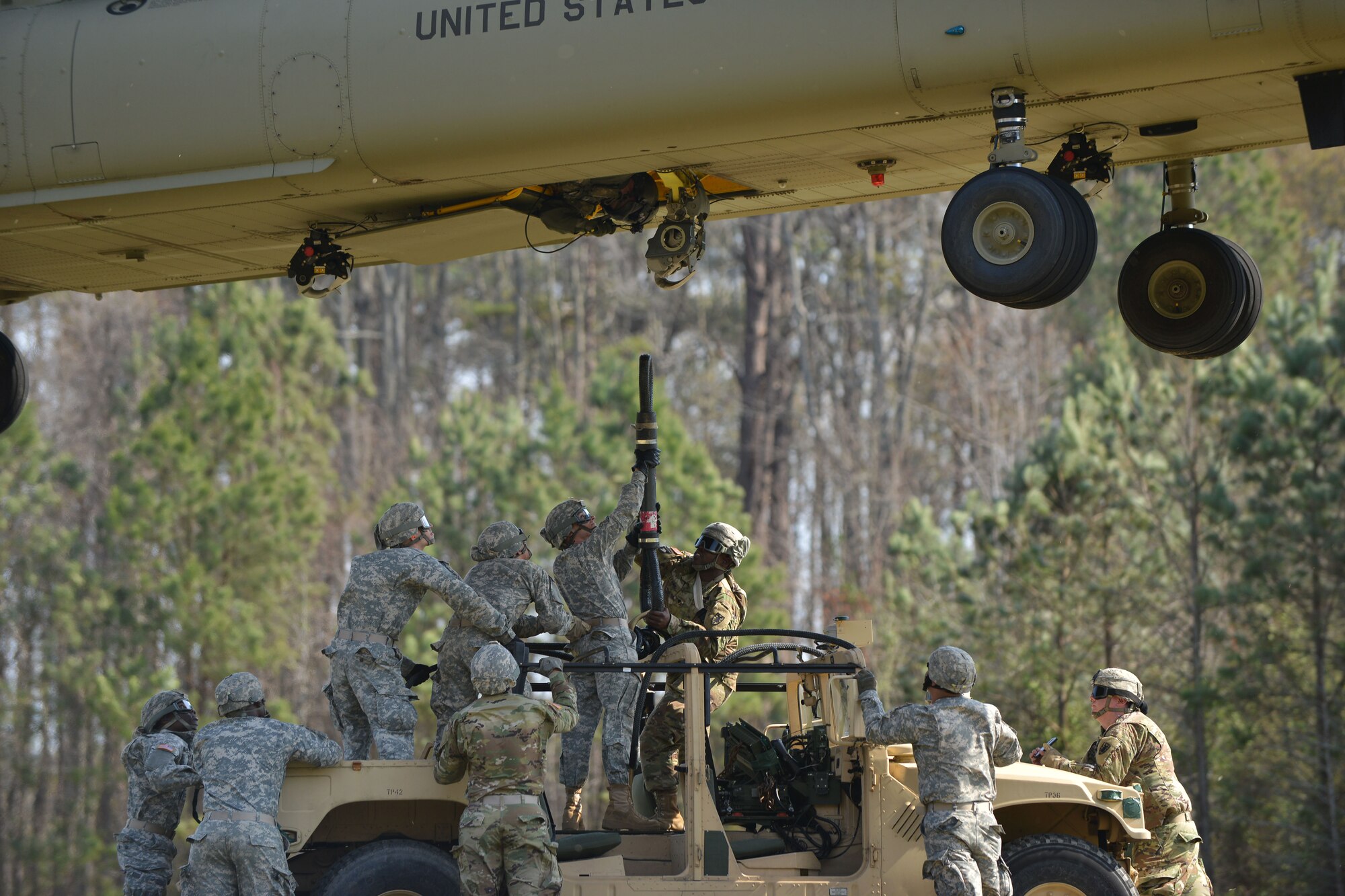 U.S. Soldiers assigned to the 689th Rapid Port Opening Element rig a high-mobility multipurpose wheeled vehicle to a CH-47 Chinook during sling-load training at Fort Eustis, Va., March 24, 2016. Sling-loading allows Soldiers to move equipment and cargo in harsh locations where roadways are unusable to transport vital materials. (U.S. Air Force photo by Staff Sgt. Natasha Stannard)