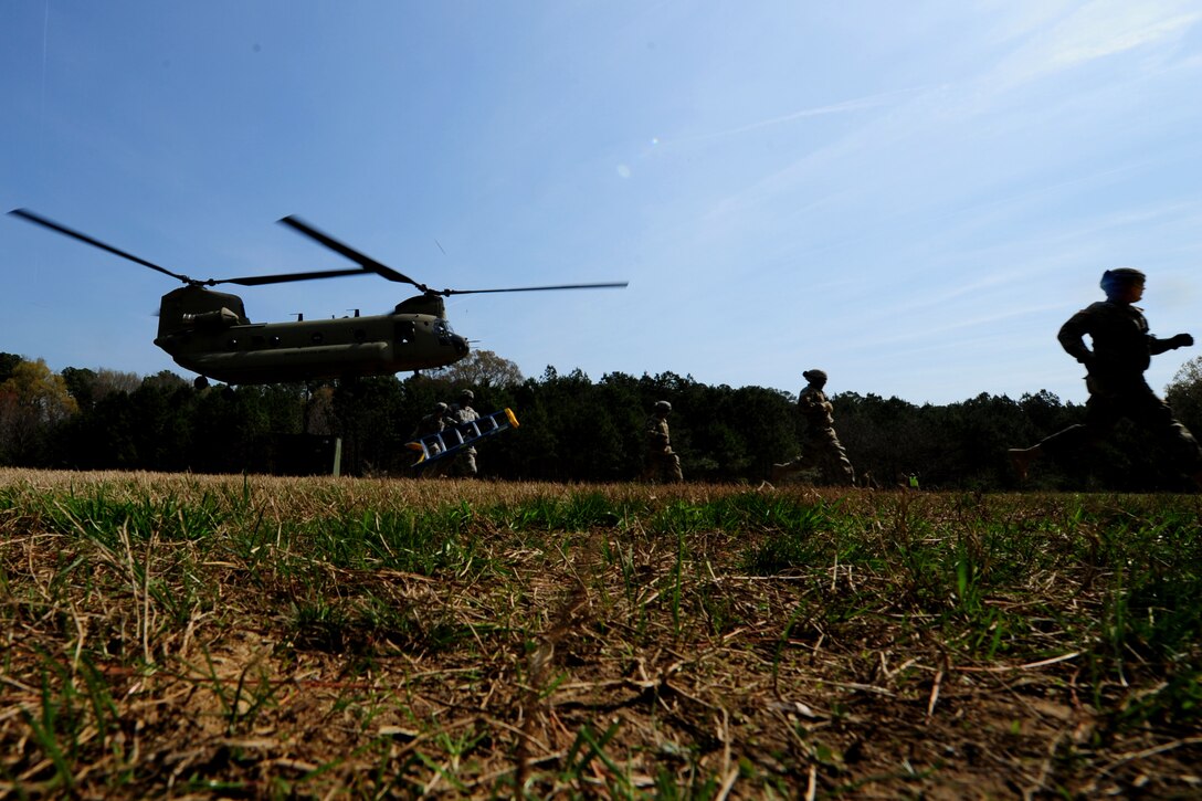 U.S. Soldiers assigned to the 689th Rapid Port Opening Element run to avoid the rotor wash of a CH-47 Chinook after conducting a sling-load at Fort Eustis, Va., March 24, 2016. The RPOE practiced several iterations of sling-loading cargo containers and vehicles as a way to master the skill that is vital to contingencies involving closed roadways. (U.S. Air Force photo by Staff Sgt. Natasha Stannard)