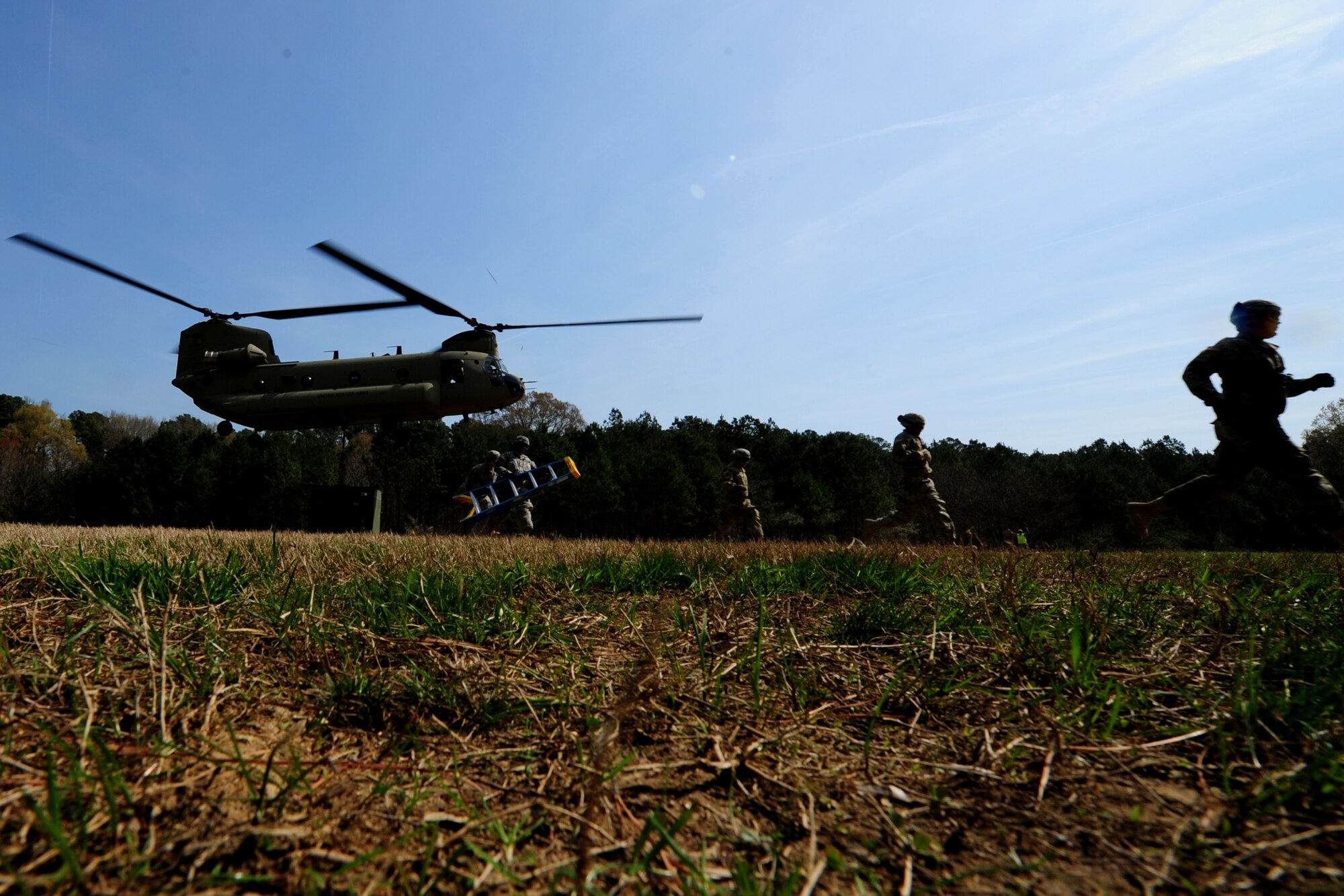 U.S. Soldiers assigned to the 689th Rapid Port Opening Element run to avoid the rotor wash of a CH-47 Chinook after conducting a sling-load at Fort Eustis, Va., March 24, 2016. The RPOE practiced several iterations of sling-loading cargo containers and vehicles as a way to master the skill that is vital to contingencies involving closed roadways. (U.S. Air Force photo by Staff Sgt. Natasha Stannard)