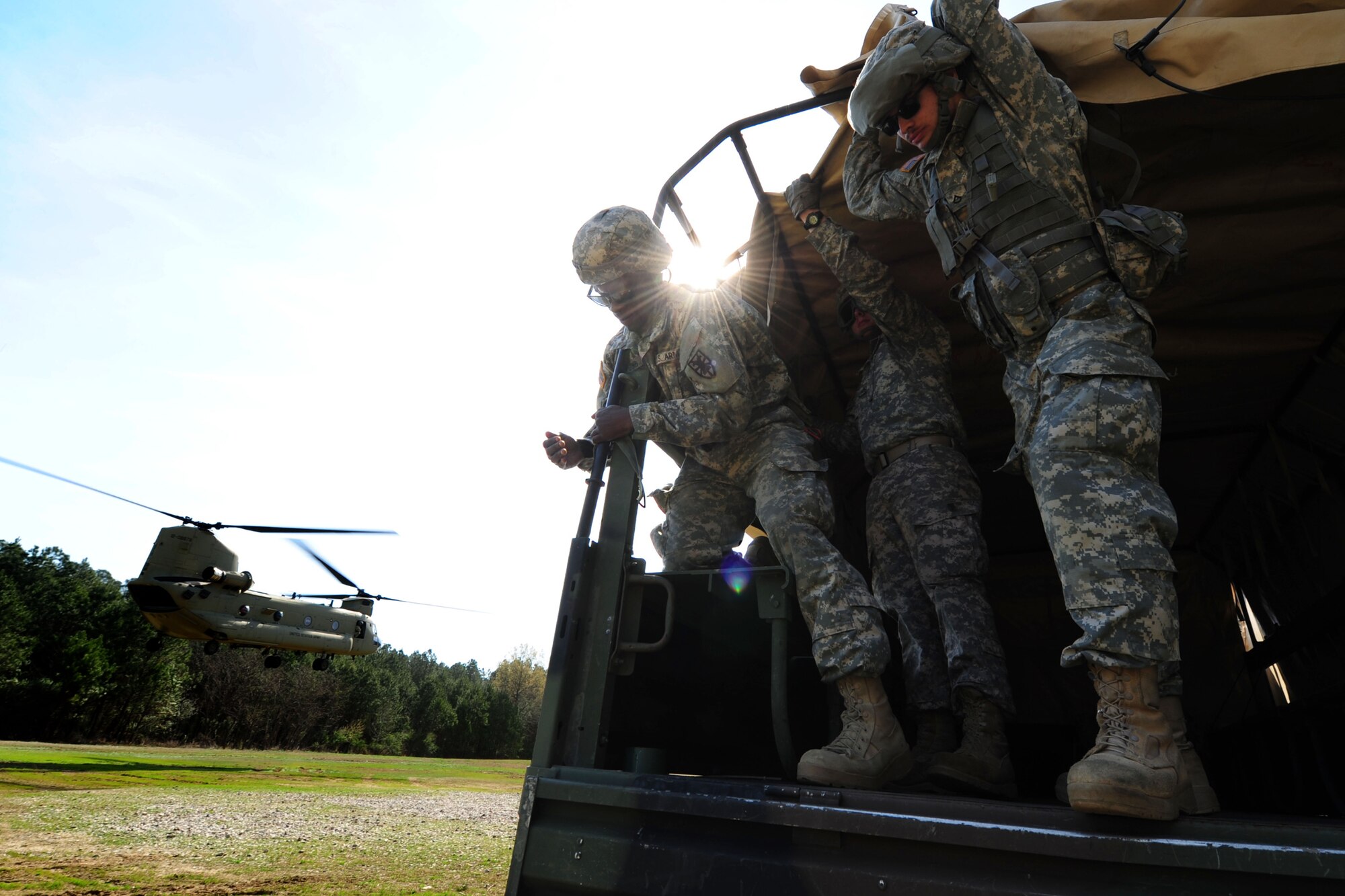 U.S. Soldiers assigned to the 689th Rapid Port Opening Element brace themselves as a CH-47 Chinook passes by during a sling-load training exercise at Fort Eustis, Va., March 24, 2016. The RPOE teamed up with the 7th Transportation Brigade and 11th Aviation Command to practice rigging cargo containers and heavy vehicles as well as familiarizing themselves with casualty evacuations. (U.S. Air Force photo by Staff Sgt. Natasha Stannard) 