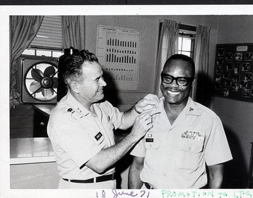 A commanding officer, pins insignia onto U.S. Army Lt. Col. Aaron M. Dotson during his promotion ceremony at Fort Eustis, Va.  During his time at Fort Eustis, Dotson established the Army Community Service to help new Soldiers and their families. (Courtesy photo)