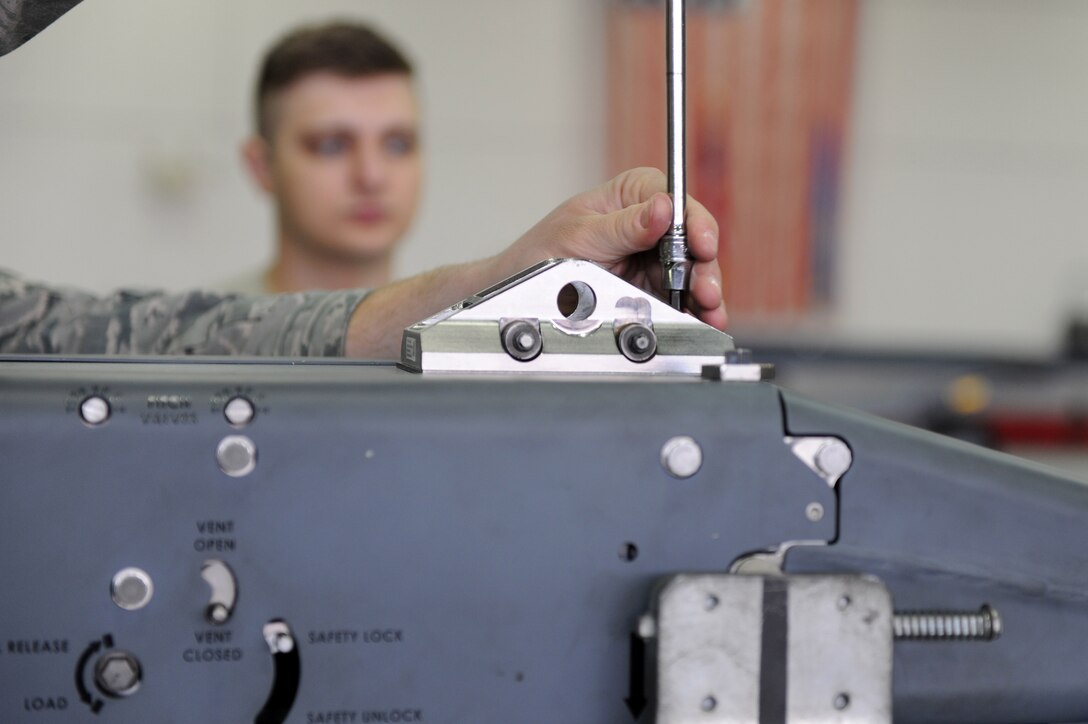 A U.S. Air Force Airman demonstrates the installation of clevis assemblies on a BRU-61 small bomb carriage system at Langley Air Force Base, Va., March 23, 2016. The clevis assembly is used to secure the BRU-61 small bomb carriage system to an aircraft. (U.S. Air Force photo by Senior Airman Brittany E. N. Murphy)