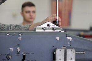 A U.S. Air Force Airman demonstrates the installation of clevis assemblies on a BRU-61 small bomb carriage system at Langley Air Force Base, Va., March 23, 2016. The clevis assembly is used to secure the BRU-61 small bomb carriage system to an aircraft. (U.S. Air Force photo by Senior Airman Brittany E. N. Murphy)