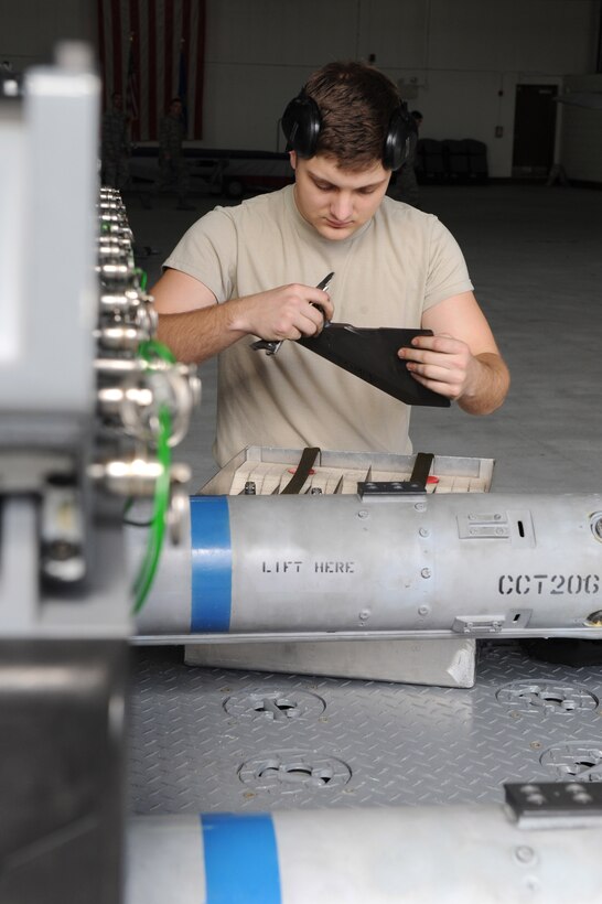 U.S. Air Force Airman 1st Class Jack O’Brien, a weapons load crew member assigned to the 27th Aircraft Maintenance Unit, inspects an AIM-120 wing during an upload operation at Langley Air Force Base, Va., March 23, 2016. Weapons load crew members receive initial week-long training to obtain certification, qualification and proficiencies needed to effectively meet safe, secure and reliable munitions loading and unloading operations. (U.S. Air Force photo by Senior Airman Brittany E. N. Murphy)