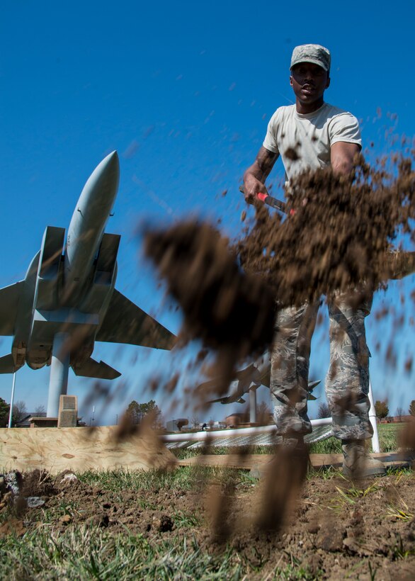 U.S. Air Force Airman Quindon Clark, a heavy equipment operator assigned to the 633rd Civil Engineer Squadron, fills a new flag post hole with dirt at Langley Air Force Base, Va., March 16, 2016. The creation of 58 new flag post holes was originally scheduled to take three weeks but was pushed back because of inclement weather. (U.S. Air Force photo by Staff Sgt. J.D. Strong II)