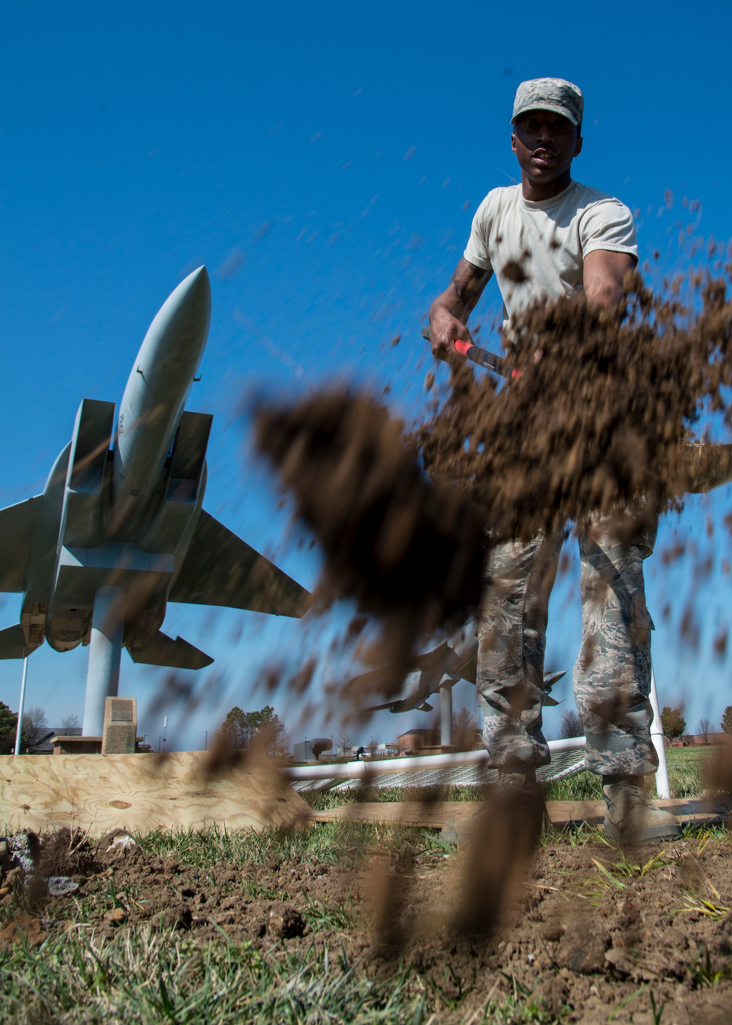U.S. Air Force Airman Quindon Clark, a heavy equipment operator assigned to the 633rd Civil Engineer Squadron, fills a new flag post hole with dirt at Langley Air Force Base, Va., March 16, 2016. The creation of 58 new flag post holes was originally scheduled to take three weeks but was pushed back because of inclement weather. (U.S. Air Force photo by Staff Sgt. J.D. Strong II)