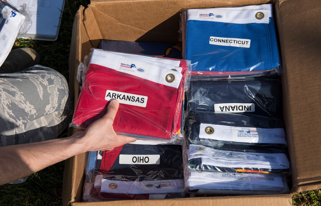 A U.S. Airman sort’s state flags at Langley Air Force Base, Va., March 25, 2016. The 633rd Civil Engineer Squadron raised all 50 states flags at Memorial Park, as well as the six U.S. territories’, Air Force and Army flags at the park. (U.S. Air Force photo by Airman 1st Class Derek Seifert)